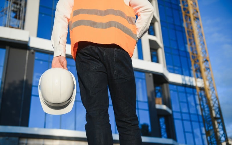 hand engineer worker holding safety helmet building site background
