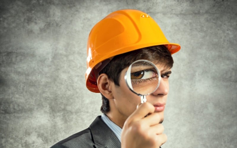 engineer looking through magnifying glass